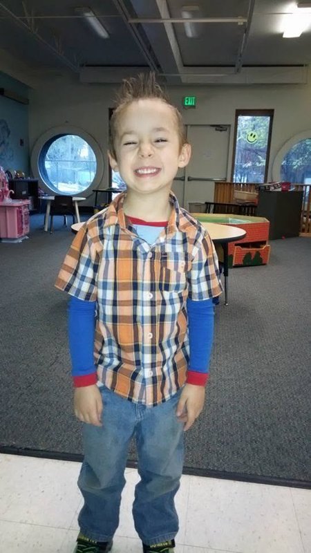 A smiling child in a classroom play area